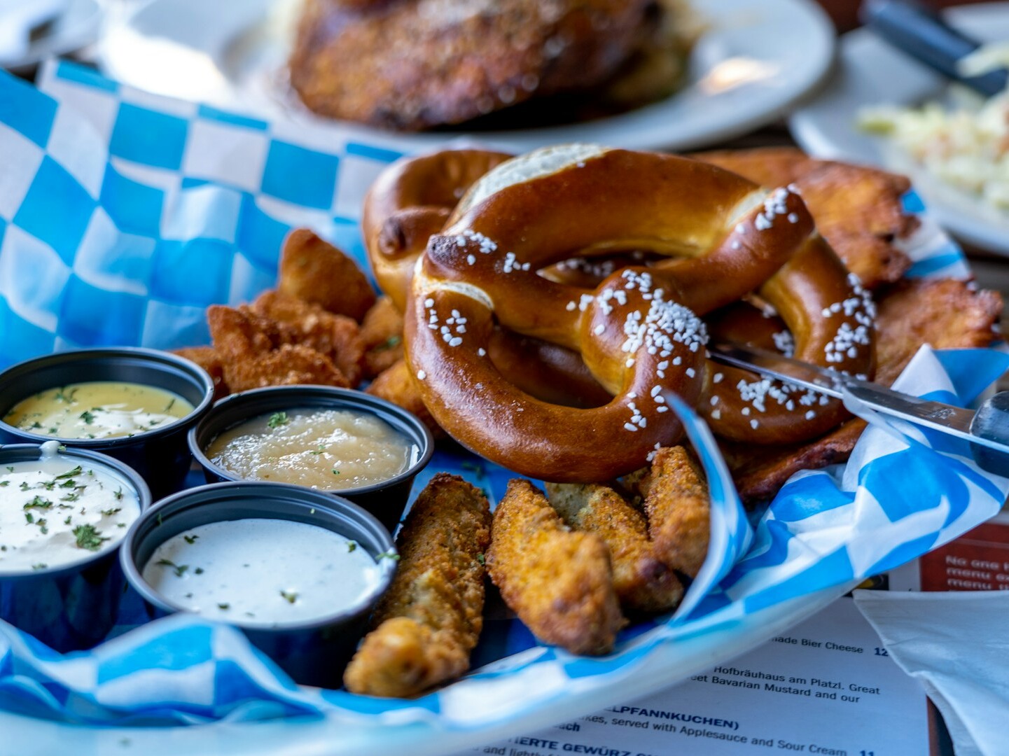 Ein Teller mit Essen, Saucen und Brezeln.