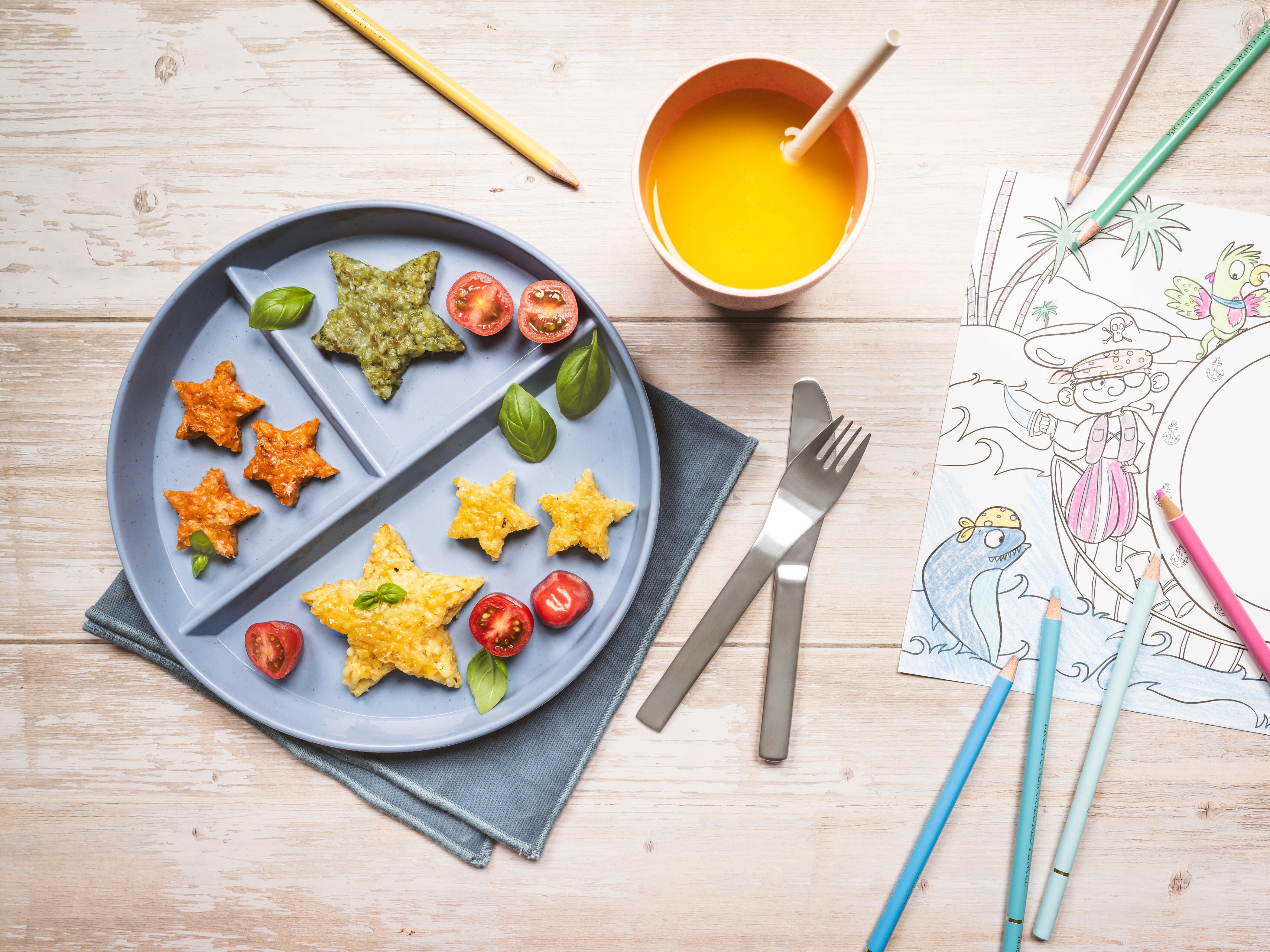 Ein Teller mit Essen, einem Getränk und Bleistiften.