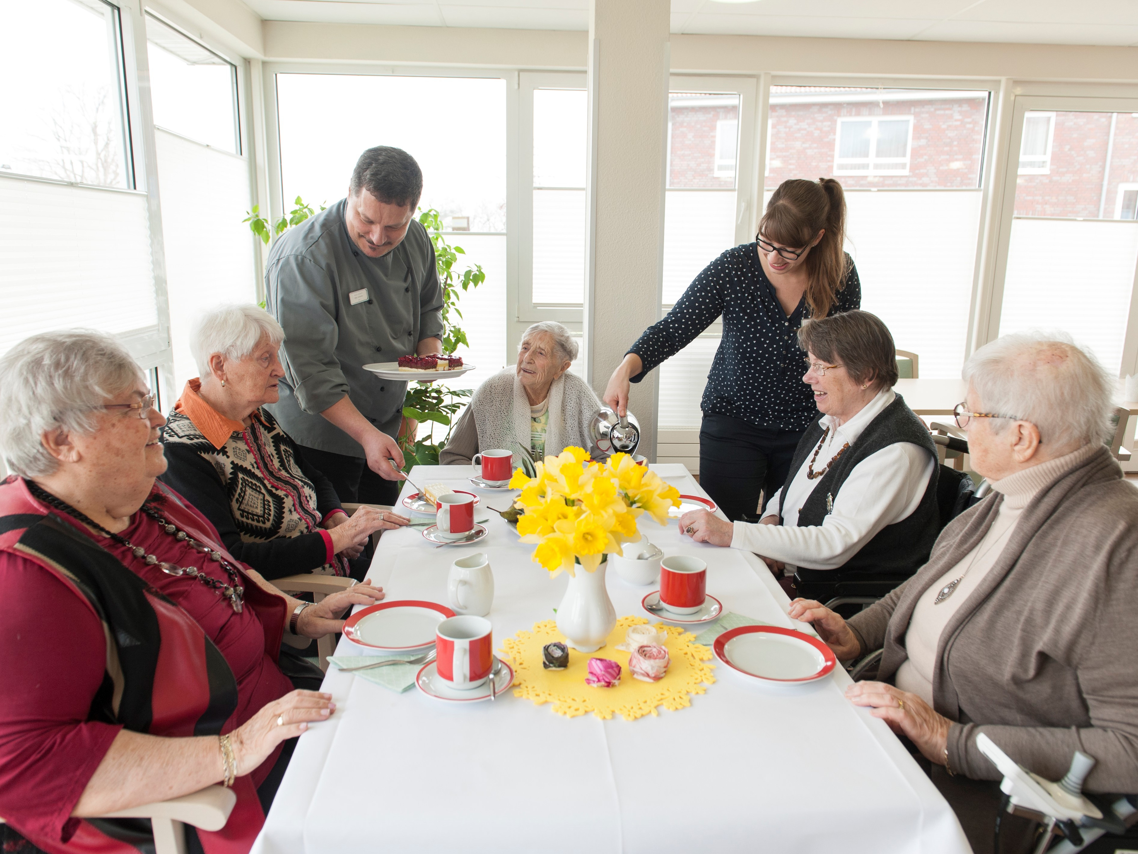 Gruppe von Personen um einen Tisch im Innenbereich