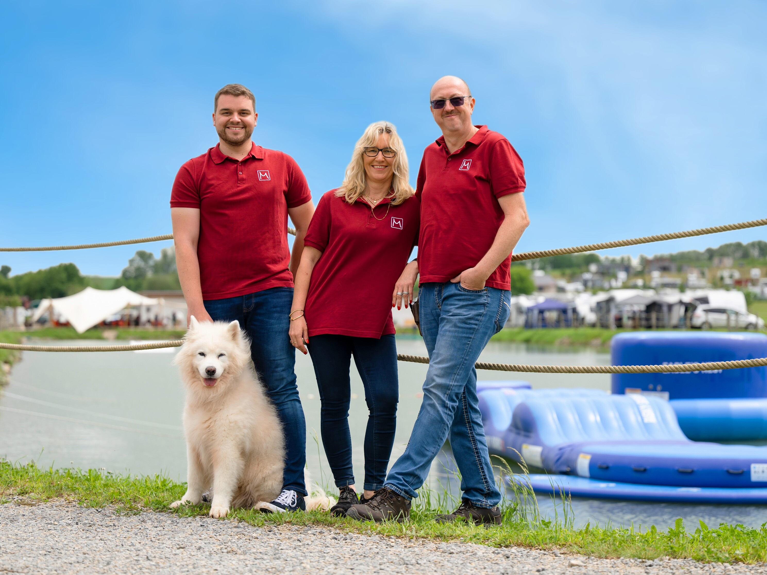 Ein Camperfeuer mit ein paar Herzen vor einem großen Feld voller Wohnmobile.